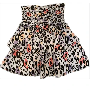 Volangkjol med leopardmönster  - Superfin kort kjol med leopardmönster med bred smock i midjan och dubbla volanger. Står ingen storlek men passar XXS/XS.