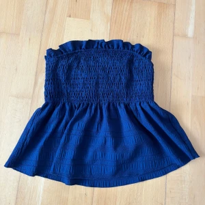 Blå topp - Supersöt mörkblå bandeau tubtopp med smockad överdel och volangkant upptill. Storlek S💕