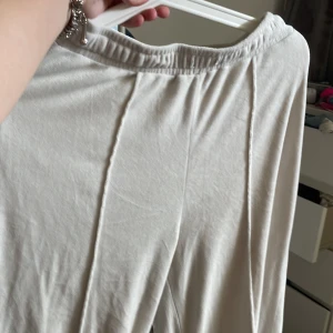 Vit långbyxor i sammet - Supermjuk och enkel vit långbyxor i sammet med resår i midjan. Byxor har en rak passform och är perfekt för dig som gillar minimalistisk stil. Materialet är lent och ger en lyxig känsla.