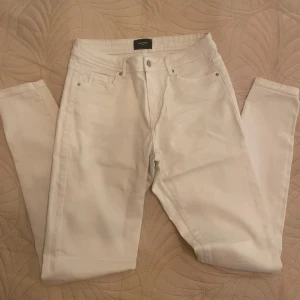 Vita jeans från Vero Moda, M/32 - Snygga vita jeans från Vero Moda i klassisk femficksmodell. Byxorna har en rak passform och är tillverkade i mjuk bomullsdenim med lite stretch. Perfekta att styla med en oversized hoodie eller en cool t-shirt.