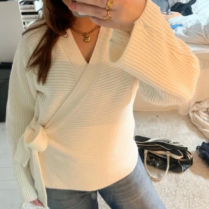 Intressekoll på kofta  - Superfin ribbstickad omlottkofta i vit färg från Gina Tricot. Koftan har långa ärmar, v-ringning och knytband i sidan som ger en snygg och trendig look. 