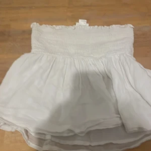Vit kortkjol från Gina Tricot - Supersöt vit topp från Gina Tricot jättebra den är väldigt stretchig så går till storlekar över 146/152