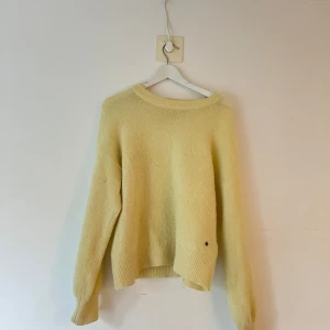 Gul stickad tröja med rund hals - Mysig ljusgul stickad tröja med rund halsringning och långa ärmar. 