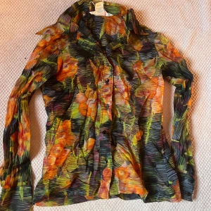 Y2K blus - Supercool 2000-tals skjorta med insperation från 70-talet. Den är i någon sorts av mesh tyg men är inte så genomskinlig som man kan tro. Den passar ungefär storlek S!