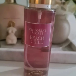 Victoria's Secret Beach Chill mist - Fräsch body mist från Victoria's Secret i doften Beach Chill. Flaskan är genomskinlig med rosa vätska och har guldfärgat lock. Doften har inslag av krispigt päron, liljekonvalj och glittrande vatten. Perfekt för dig som gillar fruktiga och blommiga toner. Helt ny och oanvänd. Förhandlar ej med priset.