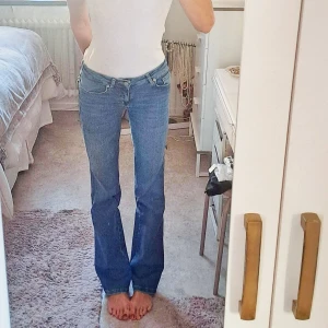 Blå bootcut jeans med låg midja - Säljer ett par klassiska blå jeans från lager 157, med bootcut-snitt och låg midja. Jeansen har fem fickor, snygga sömmar och är tillverkade i stretchig denim. Jag är 1,72. 