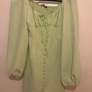 Kortklänning - Ljusgrön klänning från gina tricot med snörning fram och dragkedja på sidan. Sparsamt använd men inga spår på användning. Tunt och svalt material perfekt för sommaren! Storlek 36 Tvättar allt innan, skriv för mer bilder eller om du har några frågor.💞