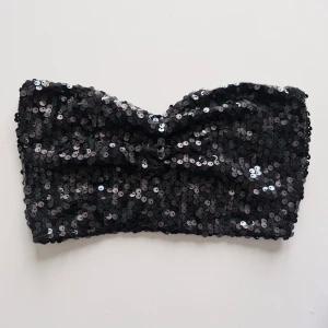 Svart paljettopp Gina Tricot - Fin bandeau-topp med paljetter från Gina Tricot! 💕 Sparsamt använd, i fint skick! Sann till storlek (S)  Höra gärna av er vid frågor och glöm inte att kolla gärna in garderoben för fler liknande plagg! Bundlerabatt finns 💗