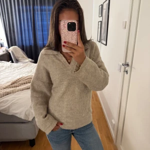Beige stickad tröja med krage från SHEIN - Mysig beige stickad tröja från SHEIN i ribbat material. Tröjan har en avslappnad passform, lång ärm och en snygg krage med v-ringning. Perfekt att styla med jeans för en chill look.🥰