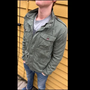 Grön field jacka  - Väldigt snygg field jacka från H&M som passar perfekt till hösten👍 jackan är i STORLEK S och Modellen är 176cm lång och väger runt 70kg.