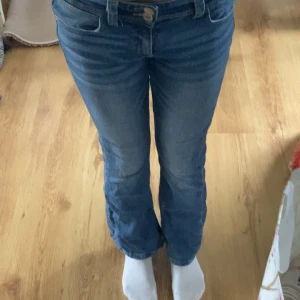 Blå bootcut jeans från Gina Tricot - Snygga blå jeans från Gina Tricot i storlek 146. Modellen har bootcut-ben och klassisk femficksdesign. Jeansen har normal midja och är tillverkade i mjukt denimtyg med lite stretch för extra komfort. 