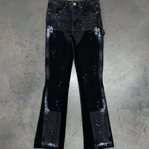 Svarta jeans med färgstänk och råa kanter - Unika svarta jeans med coola vita färgstänk och råa, slitna kanter nertill. Jeansen har en mix av mörka och ljusare partier, klassisk femficksmodell och raka ben. Perfekta för dig som vill sticka ut med en edgy streetstil.