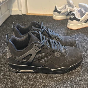 Svarta Nike Air Jordan 4 sneakers - Använda max 1 gång Säljer ett par svarta Nike Air Jordan 4 sneakers med cool meshpanel, klassisk Jumpman-logga på hälen och snygga detaljer i syntet och skinn. Skorna har snörning och en chunky sula som ger grym streetkänsla. Perfekta för dig som gillar stilrena och ikoniska sneakers.