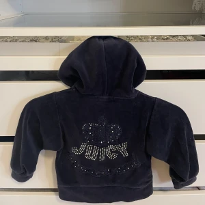 Vintage Juicy Couture kofta - Mörkblå vintage kofta från Juicy Couture i mjuk velour med glittrande stenar och broderad krona både fram och bak. Tröjan har huva, dragkedja och två fickor framtill. Nypris över 1200kr! 