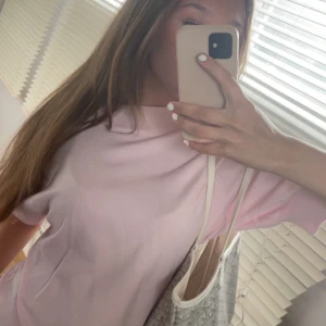 Ljusrosa stickad tröja med kort ärm - Supersöt ljusrosa stickad tröja med korta ärmar och bred ribbad krage. Tröjan har en loose passform och är perfekt för vår och sommar. Enkel och stilren design som är lätt att matcha med olika outfits. Originalpris 80€. 