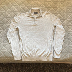 Ljusgrå half zip tröja Dressmann - ⚠️Diskuterbart pris ⚠️Säljer en stilren ljusgrå långärmad tröja från Dressmann i mjuk bomull. Tröjan har en klassisk krage och half zip-dragkedja framtill, perfekt för lager-på-lager. Supima cotton ger en skön och lyxig känsla. Passar dig som gillar enkel och clean stil.