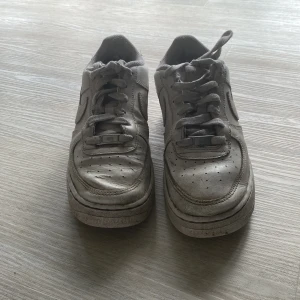 Vita Nike Air Force sneakers - Säljer ett par klassiska vita Nike Air Force sneakers. De har en rund tå och snörning framtill.