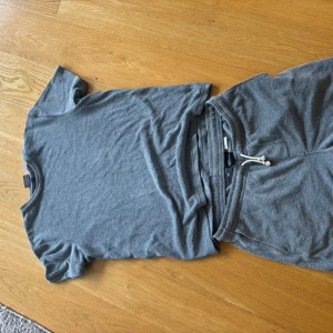 Grå mjukisset från H&M - Mjukisset från H&M i mjukt frottématerial. De har en avslappnad passform och är perfekta för chill dagar eller när du vill vara bekväm. Snygg och enkel design utan mönster, med klassisk grå färg och vita snören i midjan.