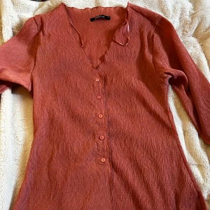 Rostfärgad långärmad tröja - Supersnygg rostfärgad tröja med lång ärm och v-ringning. 