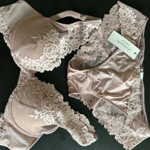 Beige/Rosa spets-BH och trosa från Intimissimi - Supersöt beigerosa set i spets från Intimissimi med blommiga detaljer och transparenta partier. Bh-n har tunna axelband och vacker broderad spets längs kanterna. Dottern var för snabb att klippa av etiketten på BHn, 70A, använd 1 gång. Trosor aldrig använda och etikett kvar, storlek S. Trosor 100 och 300 för BH. 