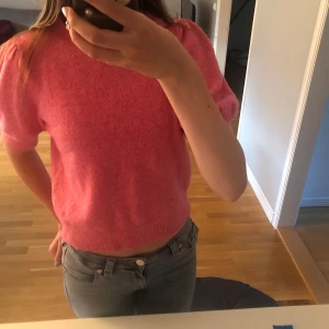 Rosa stickad kortärmad tröja - Superfin rosa stickad tröja med korta puffärmar och ribbade muddar. Perfekt för dig som vill ha en färgklick i garderoben men ändå stilren och gillar en trendig, avslappnad stil. Knappt använd! Skriv för fler bilder!