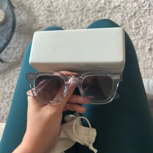 solglasögon från CHIMI 04 - Snygga solglasögon från CHIMI med transparent, fyrkantig båge i plast och mörka linser. Perfekt accessoar för att lyfta din stil. Kommer med originalfodral och påse. Storleken är Medium. 