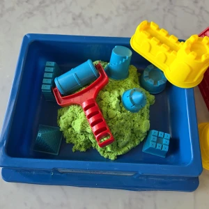 Kinetic Sand Leksaksset - Ett roligt set med kinetisk sand och tillbehör. Inkluderar en blå låda för förvaring.