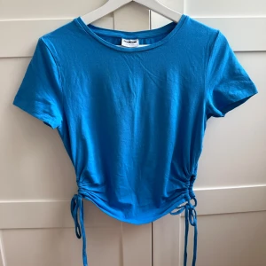 Blå topp VERO MODA - Säljer en snygg blå topp från Vero Modas kollektion ”Noisy May”. Toppen är i storlek S💙och har snygga knytdetaljer längs sidorna. Säljer pga den blev för liten💞