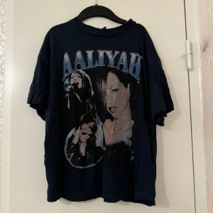 Aaliyah t-shirt  - Säljer en marinblå t-shirt från H&M med stort Aaliyah-tryck framtill. Oversized fit med korta ärmar och ribbad krage. Grym vintagekänsla och perfekt för dig som gillar streetstyle.