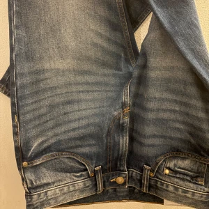 blå jeans - Klassiska H&M jeans i blå denim ”slim” med snyggt sliten tvätt och kontrastsömmar. Rak passform, fem fickor med klassiska detaljer som nitar och bakficka. Perfekta för dig som gillar en tidlös och avslappnad stil. Storlek- W32 L32
