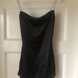 Svart satinklänning med slits - Snygg svart kortklänning i satin med tunna axelband och lätt draperad urringning. Min gamla balklänning🪽💕