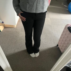 Svarta bootcut jeans True Religion - Säljer ett par svarta bootcut jeans från True Religion med snygga fickdetaljer bak och klassisk logga på linningen. Jeansen har normal passform och är tillverkade i ett stretchigt bomullsmaterial som sitter skönt och formar sig efter kroppen. Lite färg borta på knapparna på bakfickan annars nästan som nya.