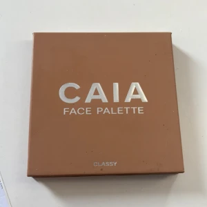 CAIA Face Palette Classy - Snygg ansiktspalett från CAIA i färgen Classy. Paletten innehåller fyra puder: en varm bronzer, en matt contour, en persikorosa rouge och en skimrande champagnefärgad highlighter. Använd men massor av produkt kvar 🙃