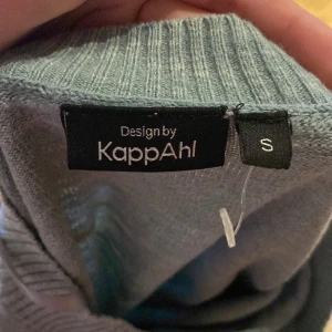 Ljusgrå twistad stickad tröja KappAhl - Superskön ljusgrå stickad tröja från KappAhl i storlek S. Tröjan har lång ärm, ribbade muddar och en snygg twistad detalj framtill som ger en cool look. Perfekt för dig som gillar en enkel men trendig stil.