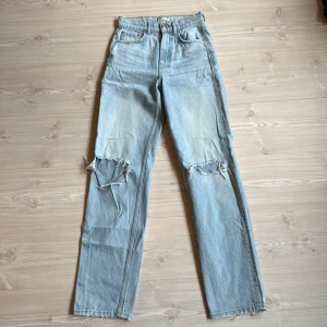 Ljusblå jeans från ginatricot  - Ljusblå högmidjade jeans med raka ben och slitningar över knäna.  
