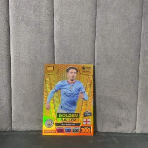 Golden Baller - Jack Grealish (Panini Adrenalyn XL 2023) - Samlar du på fotbollskort? Här är en exklusiv Golden Baller-kort med Jack Grealish från Manchester City! Perfekt för dig som älskar Premier League och vill boosta din samling med något riktigt sällsynt och glittrande.