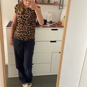 Leopardmönstrad topp XS Black Label - Snygg leopardmönstrad topp från The Black Label Collection i storlek XS. Toppen har korta ärmar och är figurnära med beige och svarta toner. Perfekt för dig som vill sticka ut med ett djurmönster. Mjuk och stretchig känsla.