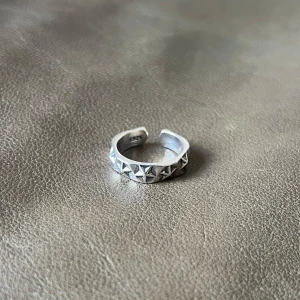 Rising Stars - Adjustable ring featuring raised star motifs that encircle the finger, creating a shimmering, celestial effect.