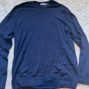 Marinblå Merinoull Tröja Dressmann XL - Schysst tröja från Dressmann. Perfekt för kommande höst/vinter. Lite uttvättad i materialet. Originalpris: 699kr