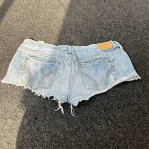 Lowrise Jeansshorts - Supersnygga lowrise jeansshorts, mått finns på bilder har ingen bild på då de är väldigt korta😇💖 Använda men har fortfarande mer kvar att ge! En liten fläck som syns på bild 3😇