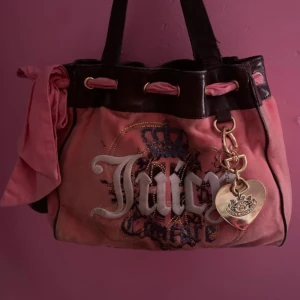 Juicy couture vintage daydreamer - Really cute vintage daydreamer bag from Juicy Couture in a beautiful pink/coral color❤️ really holds its shape although I stuffed it with blankets for the pictures. Has a pocket inside and one on the side. Really spacious, perfect for school, work etc!💕 hello kitty charm and juicy couture charm included❣️ a little peeling on handles wich can surely be treated! Also some slightly discoloration with does not stand out when wearing!