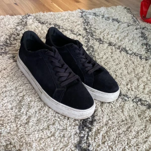 Svarta vagabord skor - Snygga svarta sneakers i mocka. Skorna har svarta snören och en stilren design som passar till jeans eller shorts. Säljer skorna pga de var för stora. Storleken är 44. Perfekta för dig som gillar enkel och clean stil.