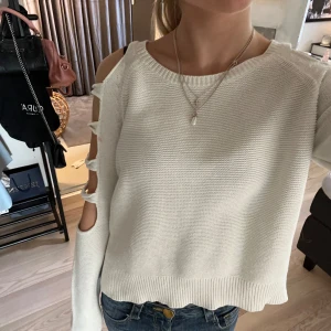 Vit stickad tröja med med detaljer på armarna - Säljer en vit stickad tröja med ”hål” längs armarna. Säljer då den inte kommer till användning längre. Den är i bra skick men har en liten rosa fläck mellan två av hålen ( se sista bilden). Skriv om ni har frågor🩷