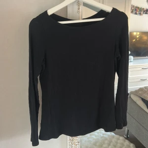 Svart långärmad tröja i bomull från Intimissimi - En enkel svart långärmad tröja från Intimissimi med rund hals. Tillverkad i mjuk bomull som känns skön mot huden. Perfekt att matcha med jeans eller kjol för en clean och chill look. Passformen är normal och materialet är tunt och följsamt.