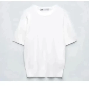 Vit t-shirt från Zara - Klassisk vit t-shirt från Zara med rund hals och korta ärmar. Enkel och stilren design som passar till allt. Tillverkad i mjuk bomull för skön komfort. Perfekt för dig som gillar minimalistisk stil.🌷