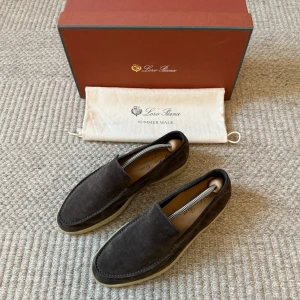 Loro Piana Summer Walk  - Mörkbruna loafers från Loro Piana i mjuk mocka med ljus gummisula. Klassisk och stilren design med rund tå och diskreta sömmar. Perfekta för en avslappnad men ändå uppklädd look. Kommer med originalkartong och dustbag.