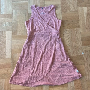 Rosa / Orange omlottklänning från Royal robbins Robbins - Snygg rosa/orange kortklänning från Royal Robbins. Passar storlek S kanske M, sitter lite löst på mig som har XS oftast. Klänningen har en jättefin omlottdesign vid bysten som ger en lätt atletisk look. Köpte denna i Italien och säljer tyvärr eftersom den har blivit för stor 💔.. Har använt 2-3 gånger och har inga hål, fläckar osv. Nyskick. Köpte för 1099kr men säljer för 500, kan ta prisförslag! 