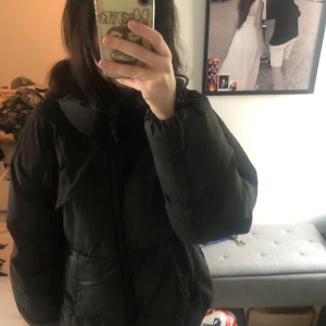 Svart pufferjacka med dragkedja - Säljer en svart pufferjacka med hög krage. Materialet är syntet och jackan har långa ärmar samt praktiska fickor på sidorna. Enkel och stilren design som funkar till många olika outfits. Sååå fin också. Nypris 500kr 