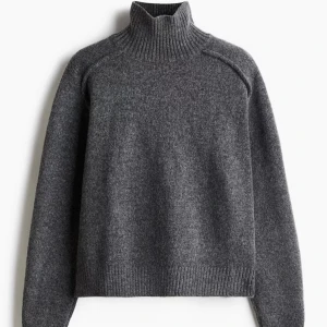 Stickad tröja  - Mörkgrå stickad tröja med en liten polokrage som även går och vika ned ifrån hm, orginalpris 300,Andvänd fåtal gånger