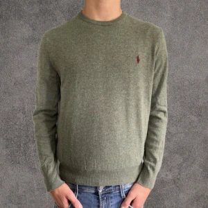 100% merinoull Ralph lauren tröja stickad - Denna stickade tröja från Ralph lauren är tillverkad i 100% merinoull som är ett riktigt mjukt material. Merinoull är ett lyxigt material därför säljs dessa tröjor dyrare en vanliga bomull. Den är i strl M men sitter som S. Modellen har en smal kroppsbyggnad och är 177 cm lång. Tröjan har ett pyttelitet hål som inte syns vid användning.